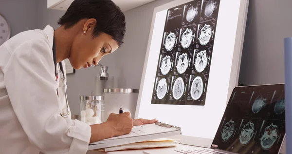 Африканских медицинских женщина, чтение рентгеновского результаты головного мозга — стоковое фото